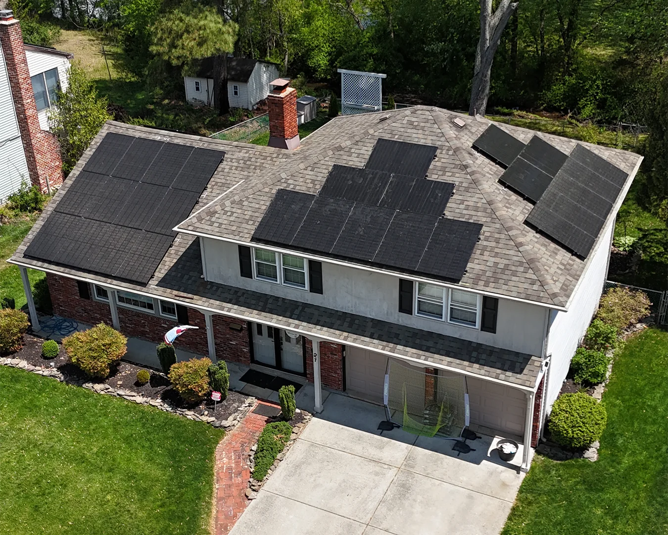 Aerial view of a two-story house with solar panels on the roof